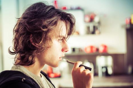 Adolescent fumant une cigarette électronique