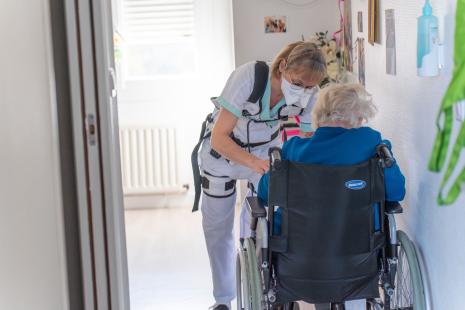 Une aide-soignante porte un exosquelette pour soulever les patients